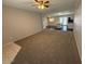 Spacious carpeted living room that flows into the kitchen featuring neutral paint and modern lighting at 15012 N 29Th Ave, Phoenix, AZ 85053