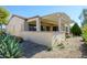 A home's backyard featuring a covered patio with stylish pergola, stucco wall, and gravel landscaping at 16935 W Desert Blossom Way, Surprise, AZ 85387
