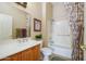 Well-lit bathroom features a shower-tub combo, floral curtains, and a neutral color scheme at 16935 W Desert Blossom Way, Surprise, AZ 85387