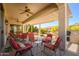 Expansive covered patio with ceiling fans, comfortable seating, and outdoor dining area at 16935 W Desert Blossom Way, Surprise, AZ 85387