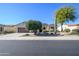 Charming home with desert landscaping, mature trees, and a well-maintained lawn at 16935 W Desert Blossom Way, Surprise, AZ 85387