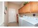 Organized laundry room with ample cabinet space, sink, and a side-by-side washer and dryer at 16935 W Desert Blossom Way, Surprise, AZ 85387