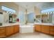 Bright main bathroom with dual vanities, a soaking tub, and a decorative glass block window at 16935 W Desert Blossom Way, Surprise, AZ 85387