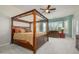 Serene main bedroom with a four-poster bed, sitting area, and natural light at 16935 W Desert Blossom Way, Surprise, AZ 85387