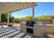 Built-in outdoor kitchen area with a barbecue grill and counter space, perfect for entertaining at 16935 W Desert Blossom Way, Surprise, AZ 85387