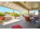 Inviting covered patio featuring an outdoor dining space, grill area, and landscaped surroundings at 16935 W Desert Blossom Way, Surprise, AZ 85387