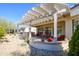 Inviting covered patio with ample seating, decorative plants, and a pergola at 16935 W Desert Blossom Way, Surprise, AZ 85387