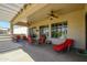 Comfortable covered patio features ceiling fans, dining table, and lounge chair, perfect for relaxing outdoors at 16935 W Desert Blossom Way, Surprise, AZ 85387