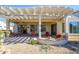 Spacious covered patio with a pergola, dining and lounge seating, views of the landscaped backyard at 16935 W Desert Blossom Way, Surprise, AZ 85387