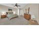 Comfortable bedroom with carpet, ceiling fan, dresser and queen-sized bed at 18298 N Kari Ln, Maricopa, AZ 85139