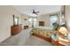 Spacious bedroom with ceiling fan, carpeted floors, and plenty of natural light from the windows at 18298 N Kari Ln, Maricopa, AZ 85139