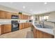 Spacious kitchen with wooden cabinets, granite countertops, and modern appliances at 18298 N Kari Ln, Maricopa, AZ 85139