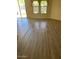 Bright living room featuring wood flooring, natural light from large windows, and access to the patio at 18298 N Kari Ln, Maricopa, AZ 85139