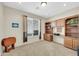 Carpeted office space with built-in desk and shelving with a large window for natural light at 18298 N Kari Ln, Maricopa, AZ 85139