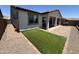 A spacious backyard with artificial turf, brick pavers, and a covered patio for outdoor entertaining and relaxation at 20407 W Calle Encorvada --, Buckeye, AZ 85396
