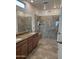 Modern bathroom featuring dual sinks, granite countertops, and a glass-enclosed shower with bench seating at 20407 W Calle Encorvada --, Buckeye, AZ 85396