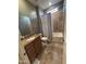 Well-lit bathroom with a tub-shower combination, granite vanity, and neutral-toned tile flooring at 20407 W Calle Encorvada --, Buckeye, AZ 85396