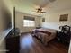 Bedroom showcasing hardwood floors, a ceiling fan, a large window and a neatly made queen bed at 20407 W Calle Encorvada --, Buckeye, AZ 85396