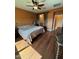 Warm bedroom with hardwood floors, ceiling fan, and barn door access to the bathroom at 20407 W Calle Encorvada --, Buckeye, AZ 85396
