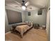Bedroom with gray walls, wood-look floors, ceiling fan and small windows at 20407 W Calle Encorvada --, Buckeye, AZ 85396