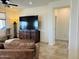 Comfortable living room featuring tile floors, a mounted flat screen television, and neutral paint colors at 20407 W Calle Encorvada --, Buckeye, AZ 85396