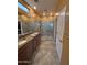 Main bathroom with a dual sink vanity, tiled walk-in shower, and ample lighting at 20407 W Calle Encorvada --, Buckeye, AZ 85396