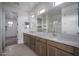 Bathroom with dual sinks, walk-in closet, and bright mirrors at 21291 W Edgemont Ave, Buckeye, AZ 85396