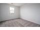 Neutral bedroom featuring carpet, a window, base trim, and white walls at 21291 W Edgemont Ave, Buckeye, AZ 85396