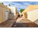 Private backyard with stone pavers, gravel accents, and a walkway to an archway on a sunny day at 2157 N Recker Rd, Mesa, AZ 85215