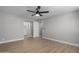 Primary bedroom with fan, wood-look flooring and view to primary bath at 2157 N Recker Rd, Mesa, AZ 85215