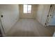 Unfinished bedroom with tiled flooring, one window and freshly painted door, awaiting personalization at 29022 N 166Th Ave, Surprise, AZ 85387