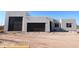 Modern home exterior featuring a stucco facade, dark garage doors, and desert landscaping at 29022 N 166Th Ave, Surprise, AZ 85387