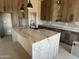 Beautiful kitchen featuring a waterfall island, custom cabinetry, marble countertops, and modern fixtures at 29022 N 166Th Ave, Surprise, AZ 85387