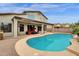 Backyard pool with curved design, surrounding patio, and covered seating area at 3099 E Runaway Bay Pl, Chandler, AZ 85249