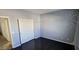 Neutral bedroom featuring wood floors, sliding door closet, and subtle tree mural at 3113 E Danbury Rd # 5, Phoenix, AZ 85032