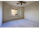 Neutral bedroom with large window, ceiling fan, and plush carpet at 39424 N Spur Cross Rd, Cave Creek, AZ 85331