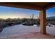 Inviting pool area featuring a rock waterfall, desert views, and a covered patio, perfect for outdoor relaxation and entertaining at 39424 N Spur Cross Rd, Cave Creek, AZ 85331