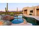 Inviting pool and spa area with desert landscaping, a covered patio and mountain views at 39424 N Spur Cross Rd, Cave Creek, AZ 85331