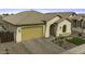 A beautifully landscaped single-story home featuring a tan color scheme and tile roof at 41262 W Almira Dr, Maricopa, AZ 85138