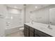 Bathroom featuring double sinks, a large mirror, and a shower-tub combination with updated fixtures at 42860 W Palo Abeto Dr, Maricopa, AZ 85138