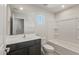 Bathroom featuring a dark wood vanity, a bathtub with white tile surround and a framed mirror at 42860 W Palo Abeto Dr, Maricopa, AZ 85138