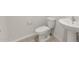 A simple and clean half bathroom with a pedestal sink, toilet, and tile flooring at 42860 W Palo Abeto Dr, Maricopa, AZ 85138