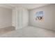 A bedroom painted light grey and featuring a large window and light-colored carpet at 42860 W Palo Abeto Dr, Maricopa, AZ 85138