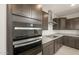 Modern kitchen features stainless steel appliances, granite countertops, and dark wood cabinetry at 42860 W Palo Abeto Dr, Maricopa, AZ 85138