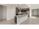 Modern kitchen with a large granite island, stainless steel appliances, and built-in oven at 42860 W Palo Abeto Dr, Maricopa, AZ 85138