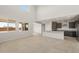 Bright, open-concept living space with kitchen island, tall ceilings, and large windows at 42860 W Palo Abeto Dr, Maricopa, AZ 85138