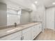 Modern bathroom with dual sinks, quartz counters, white cabinets, and a walk-in shower at 42965 W Palo Abeto Dr, Maricopa, AZ 85138