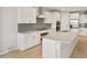 Modern kitchen with white cabinets, stainless steel appliances, and a spacious island at 42965 W Palo Abeto Dr, Maricopa, AZ 85138
