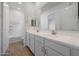 Bathroom featuring double sinks, white cabinets, and wood-look tile flooring at 44729 N 44Th Dr, Phoenix, AZ 85087