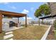 Backyard featuring outdoor kitchen, bar with grill and sink under a covered pergola in a grass backyard at 4612 S Dorsey Ln, Tempe, AZ 85282